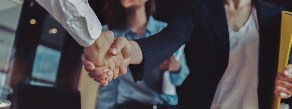 young,business,people,shaking,hands,in,the,office.,finishing,successful