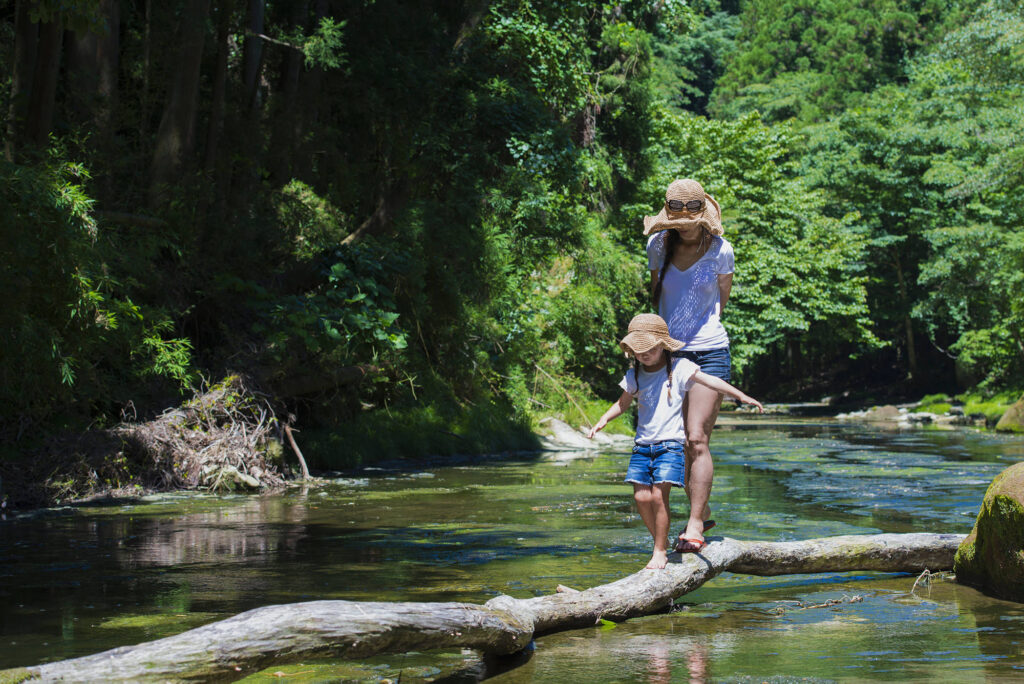 about mother,and,daughter,playing,on,mountain,stream